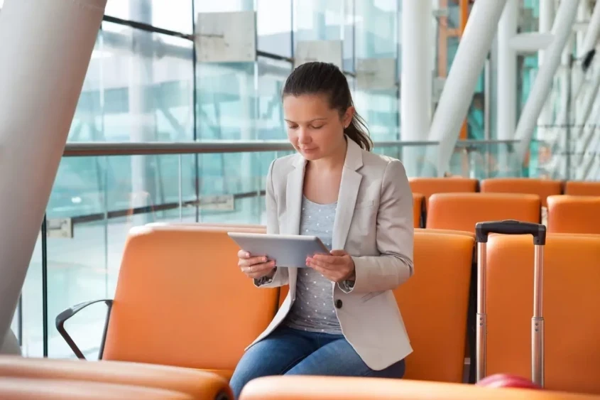 Passenger checking her Ryanair compensation claim on a tablet at the airport