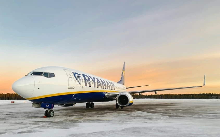 Ryanair plane on a snowy tarmac at sunset