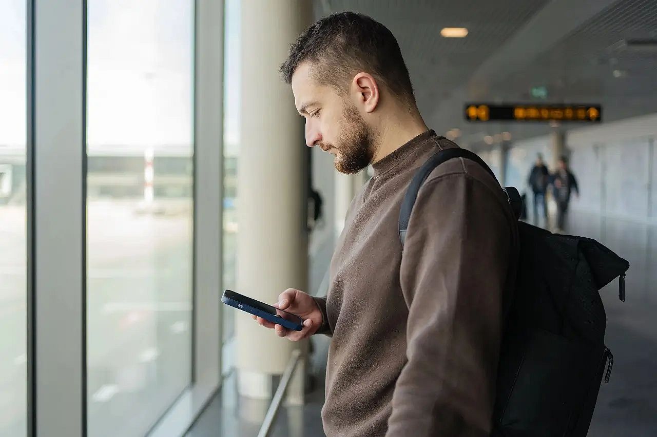 Man at airport checking insurance policy