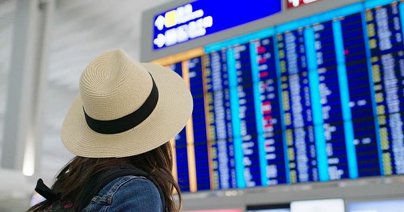 Mujer mirando en panel de información con los vuelos del aeropuerto de Tenerife Norte