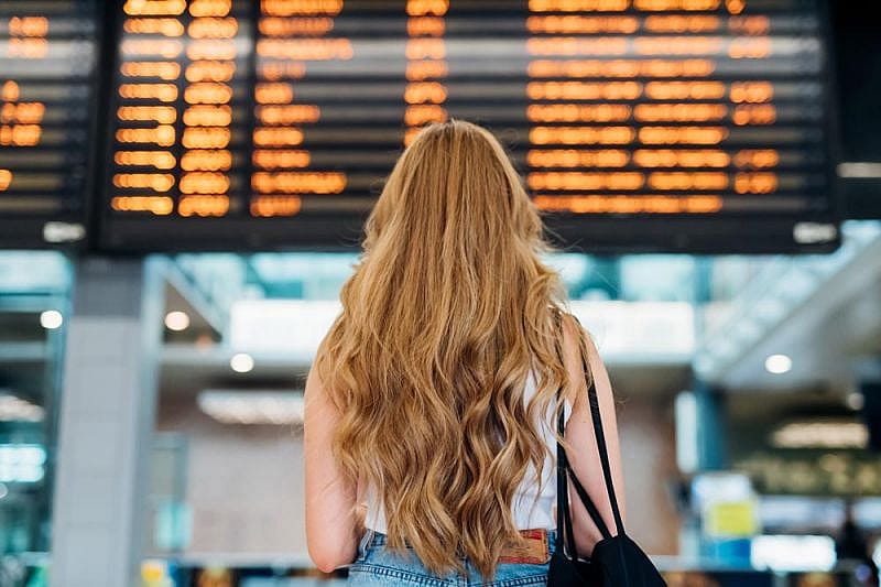 Pasajera comprueba en un panel de información la cancelación de un vuelo de Canaryfly