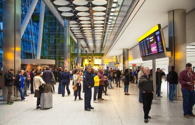 Passengers wait at the terminal after a canceled American Airlines flight