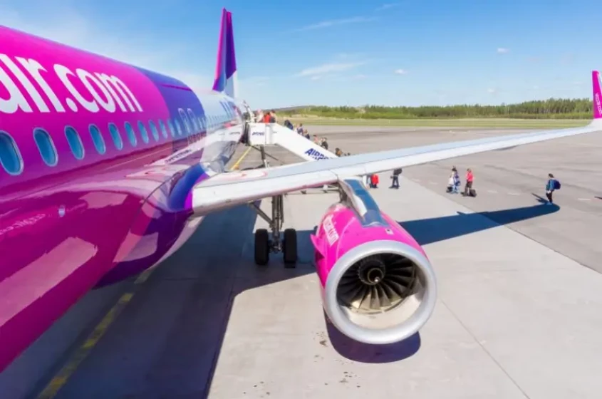 Ala e motore di aereo Wizz Air e passeggeri che salgono a bordo