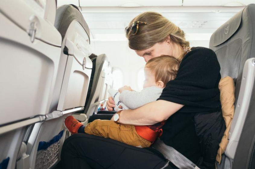 En mamma med ett spädbarn på ett flygplan