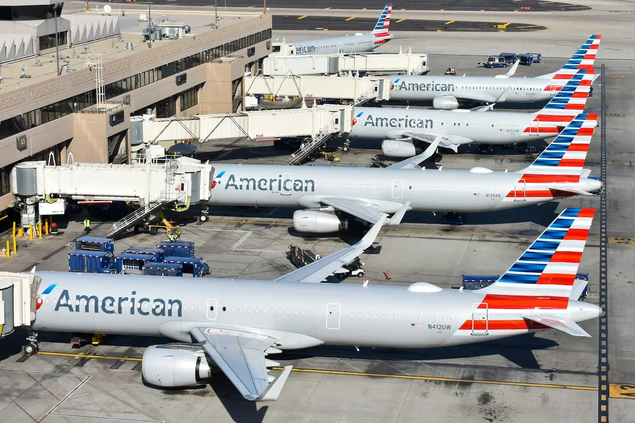 Five American Airlines planes parked at the gate, ready for checked baggage loading
