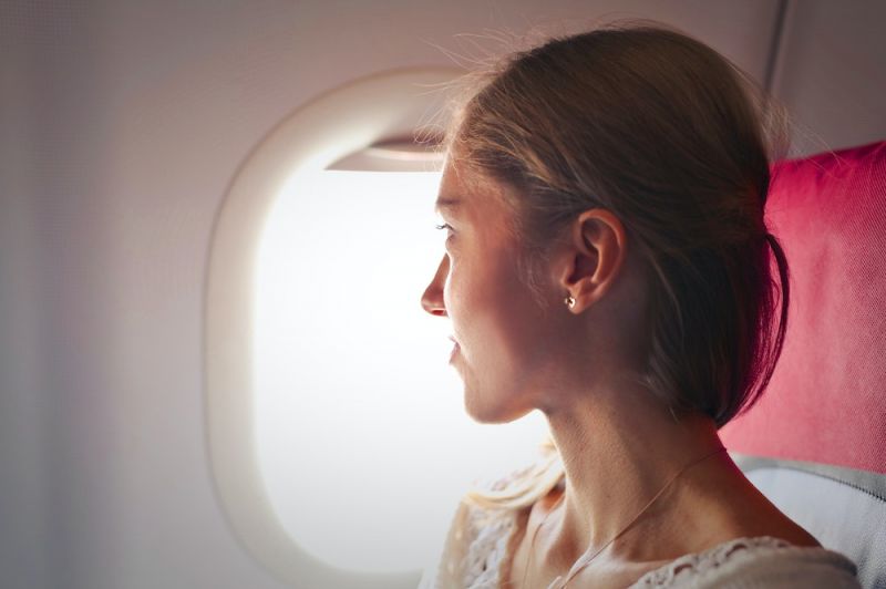 Frau schaut aus dem Flugzeug