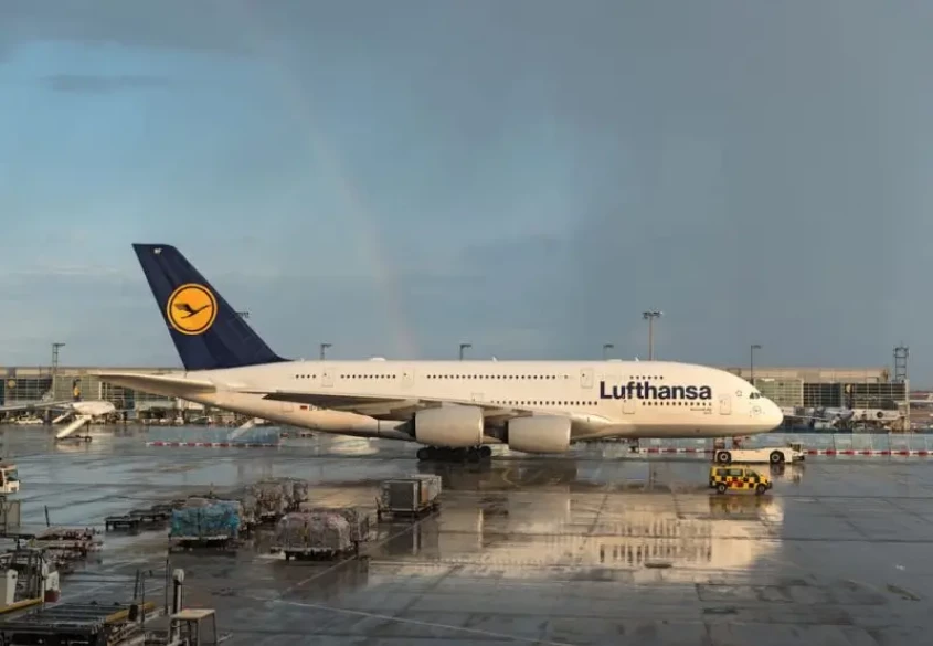 Genrebild över en Lufthansa flygplan med en regnbåge över sig.