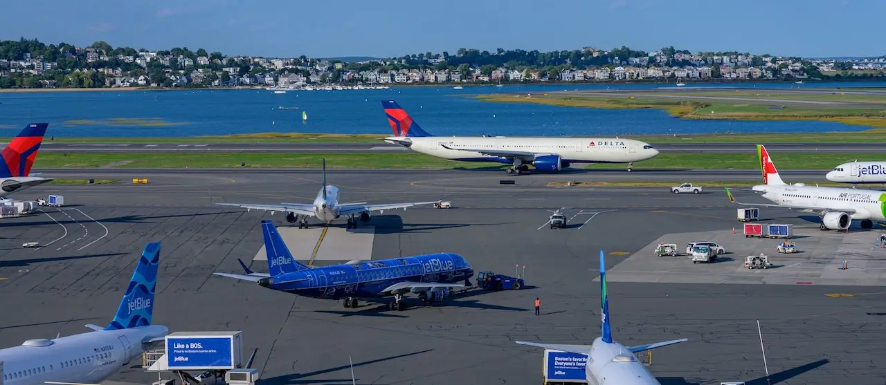 Multiple US planes parked at Boston Logan Airport on a sunny day