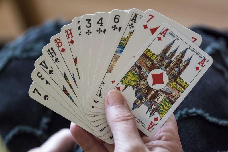 a woman holding playing cards in her hand