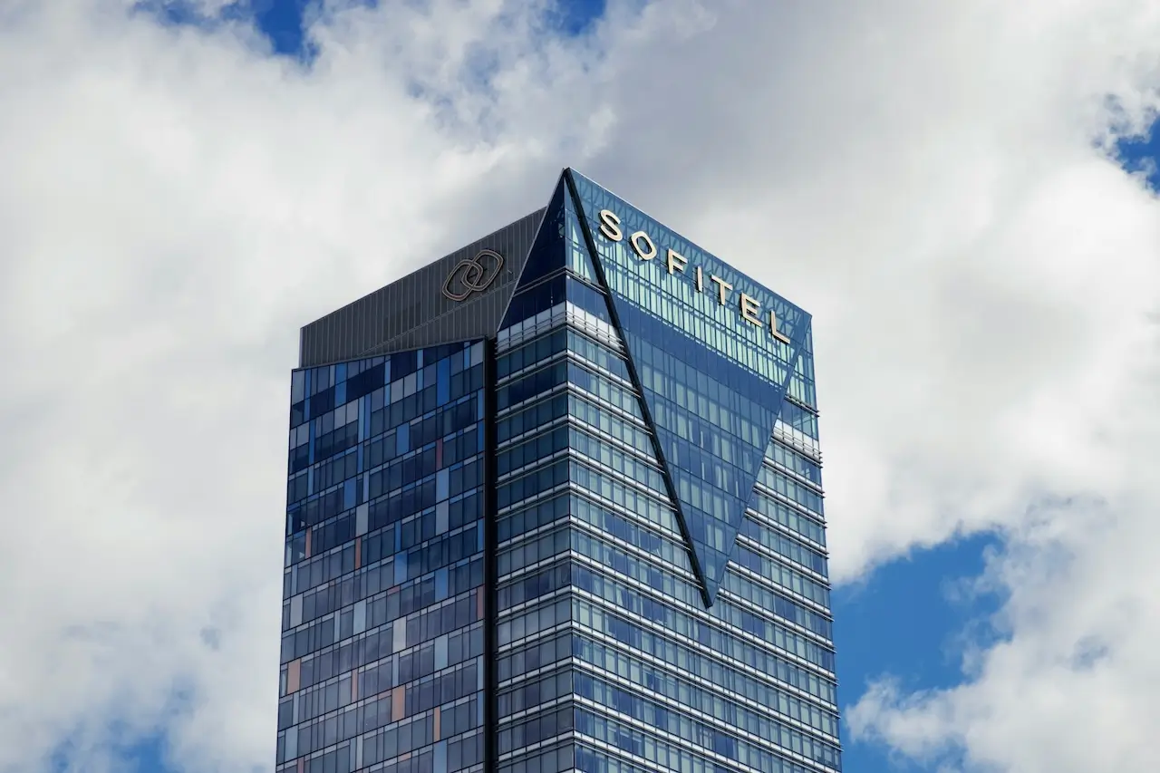 A hotel in Sydney Harbour with blue sky and clouds behind it