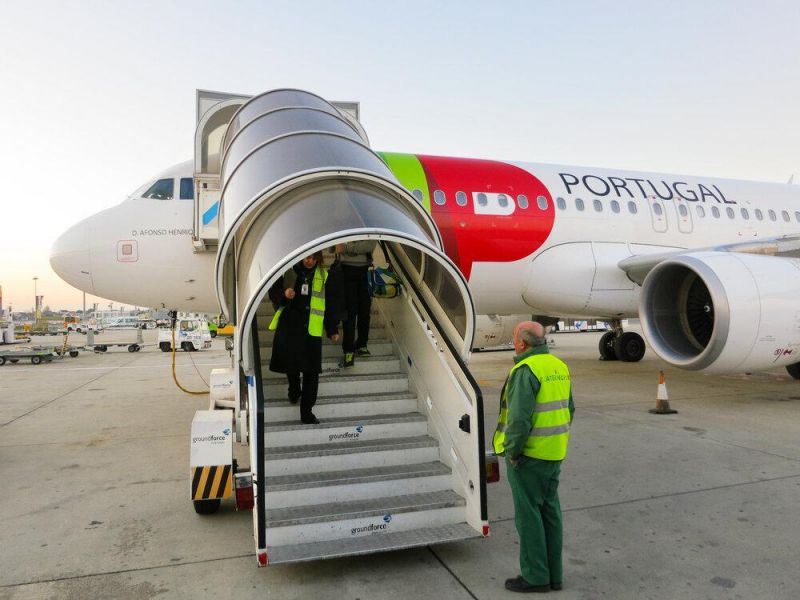 Crew members step off a delayed TAP Portugal flight