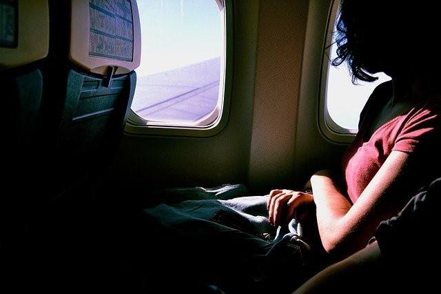 Une femme regarde par la fenêtre de l’avion