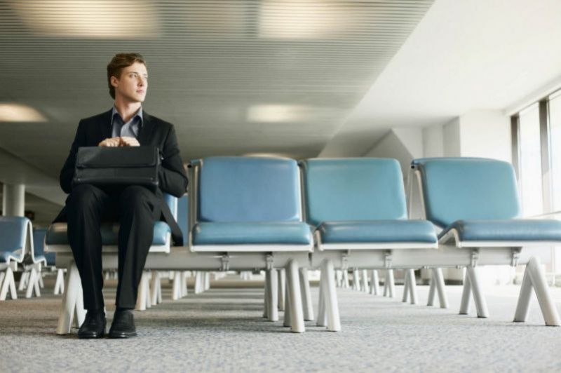 Uomo d’affari che aspetta seduto in aeroporto