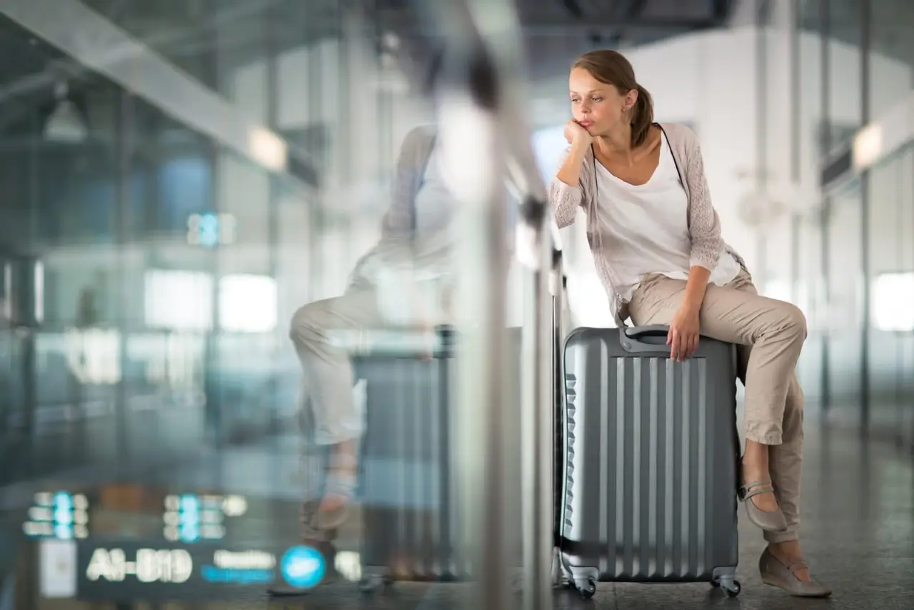 une passag&egrave;re assize sur sa valise