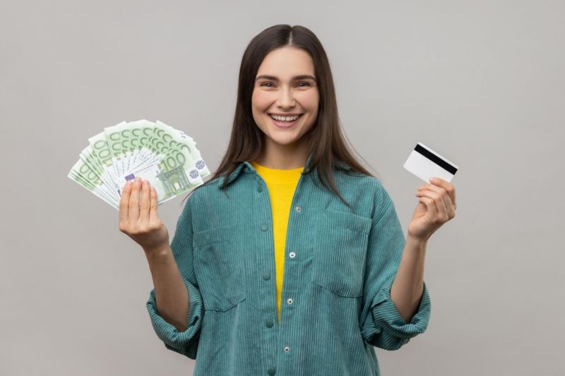 Pasajera sonriente sosteniendo dinero en efectivo tras cobrar su indemnización por vuelo
