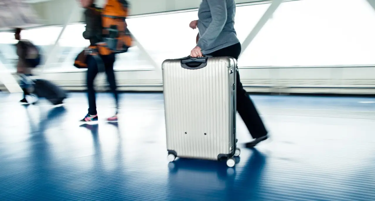 les voyageurs avec valises marchent dans un a&eacute;roport