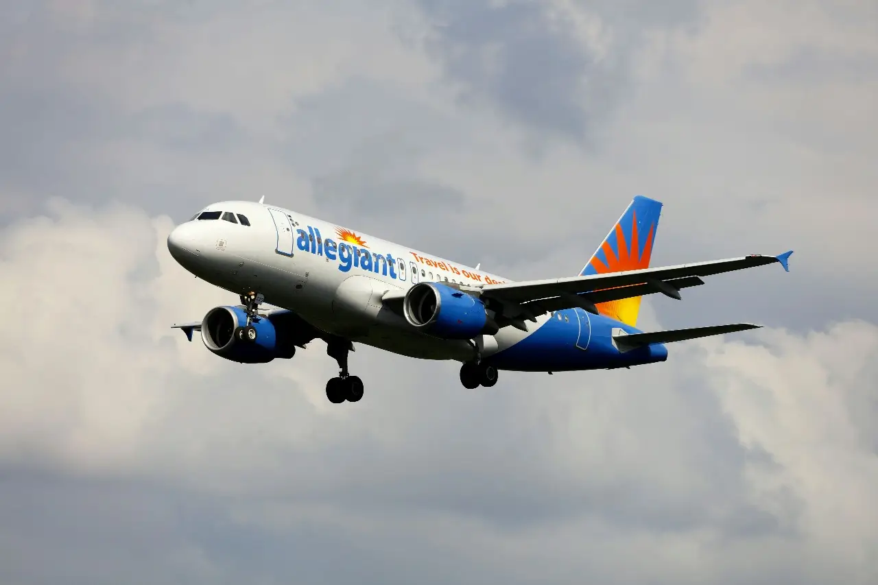 An Allegiant plane flying in a cloudy sky