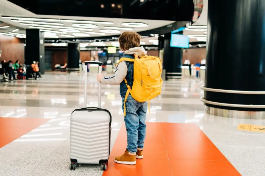 un gar&ccedil;on avec des bagages dans un a&eacute;roport