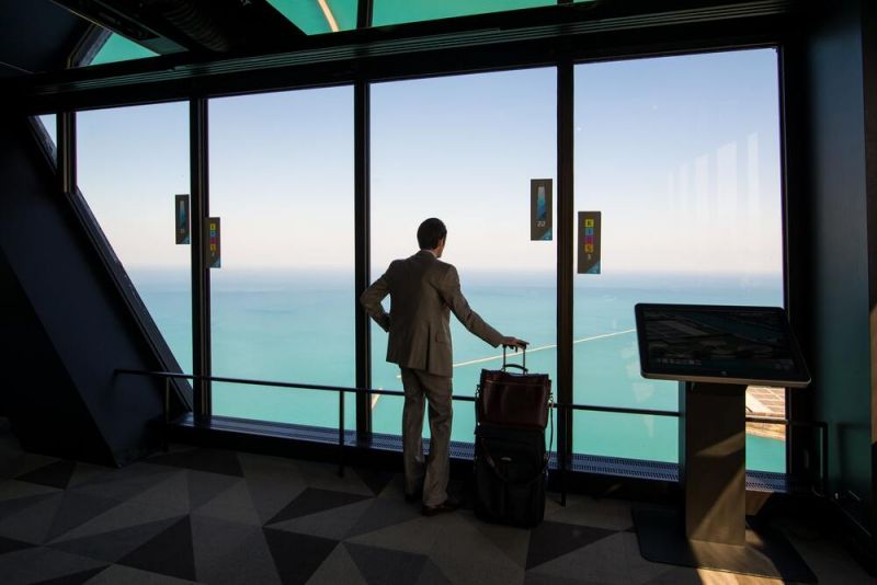  uno de los viajeros de negocios que mira fuera de la ventana del aeropuerto