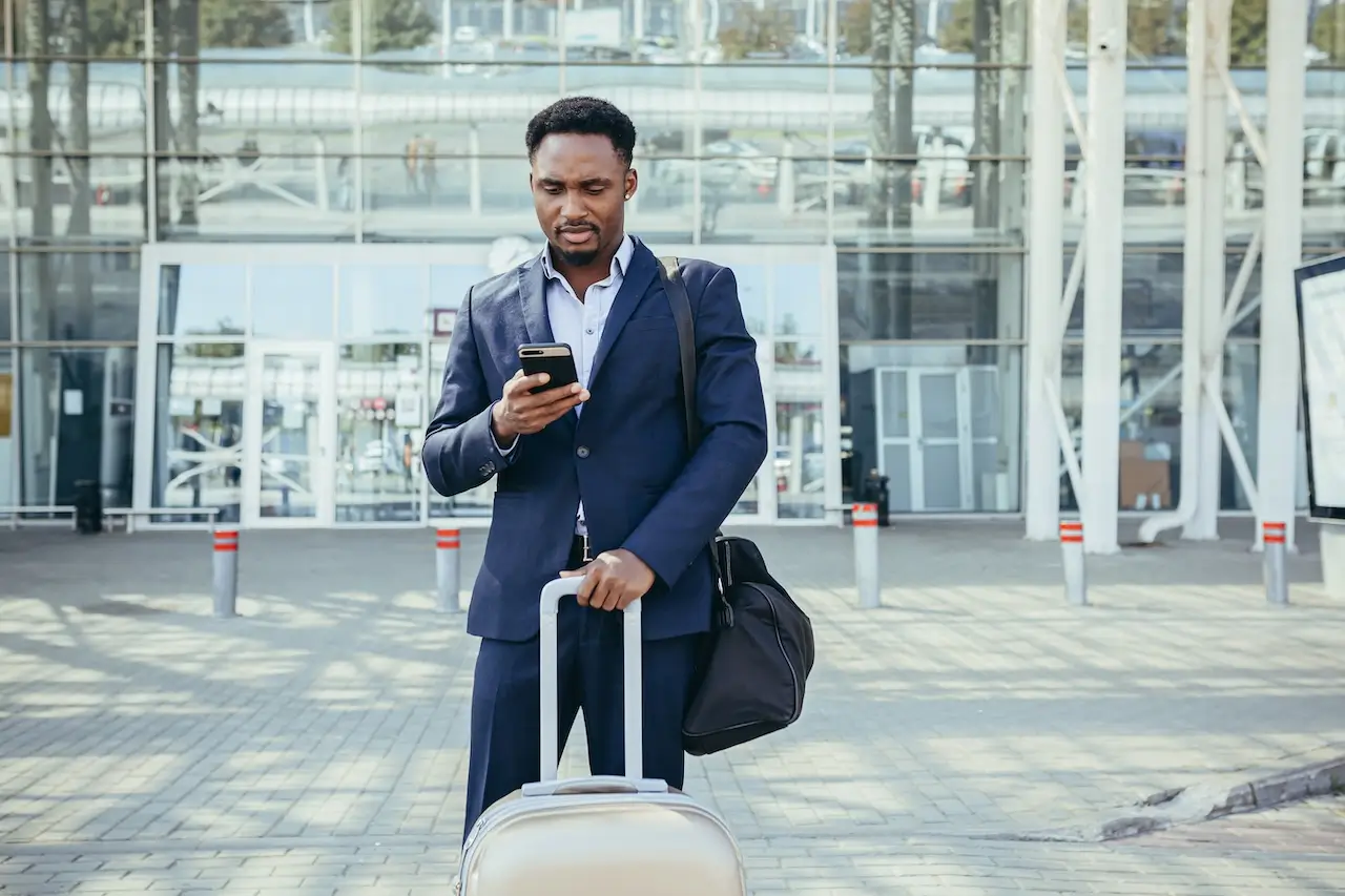 businessman near airport calling taxi using mobile app