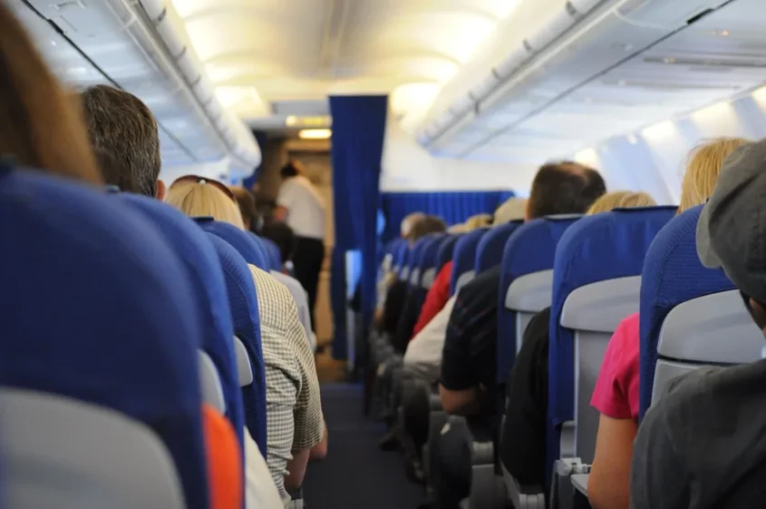Passageiros sentados na cabine de um avi&atilde;o
