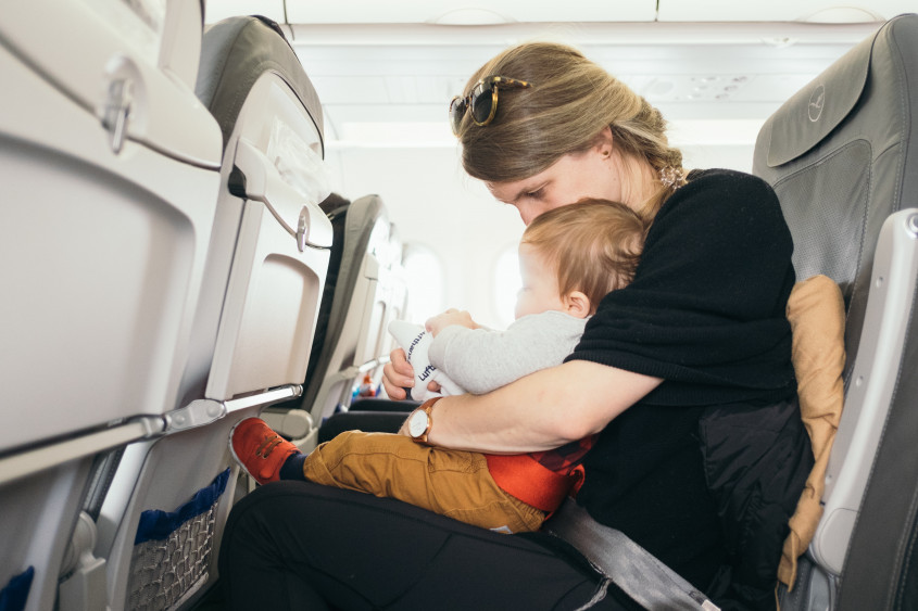 een vrouw met kind in het vliegtuig