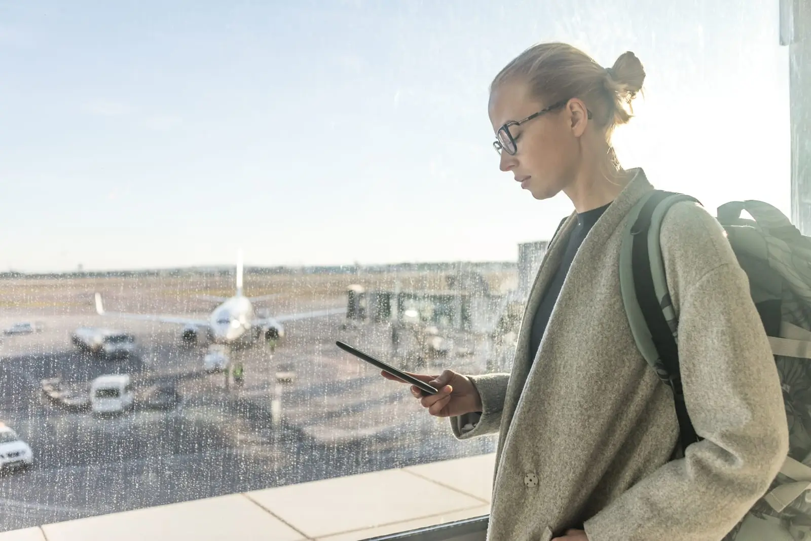 female traveler at airport looking at smartphone