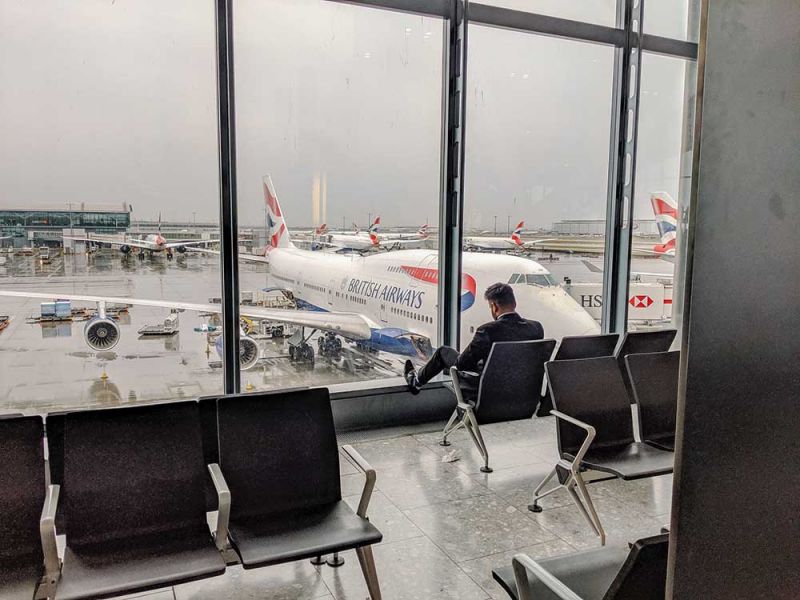 Hombre sentado en el aeropuerto ejerciendo sus derechos por cancelación de vuelo