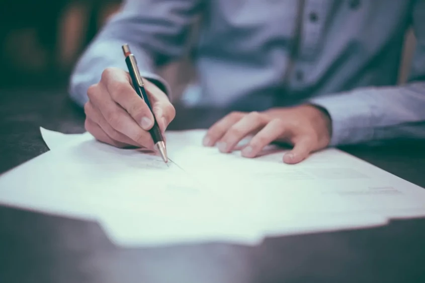 homem a assinar um documento de reclama&ccedil;&atilde;o