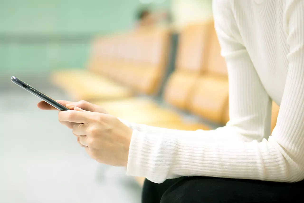 kobieta na lotnisku pisze sms y na smartfonie