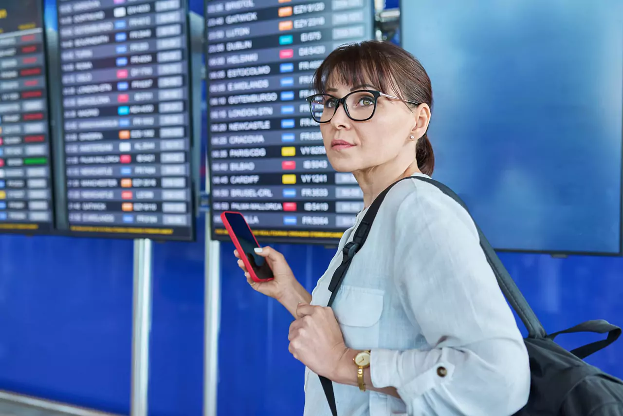 kvinna passagerare titta pa flyg schema ombord pa flygplatsen