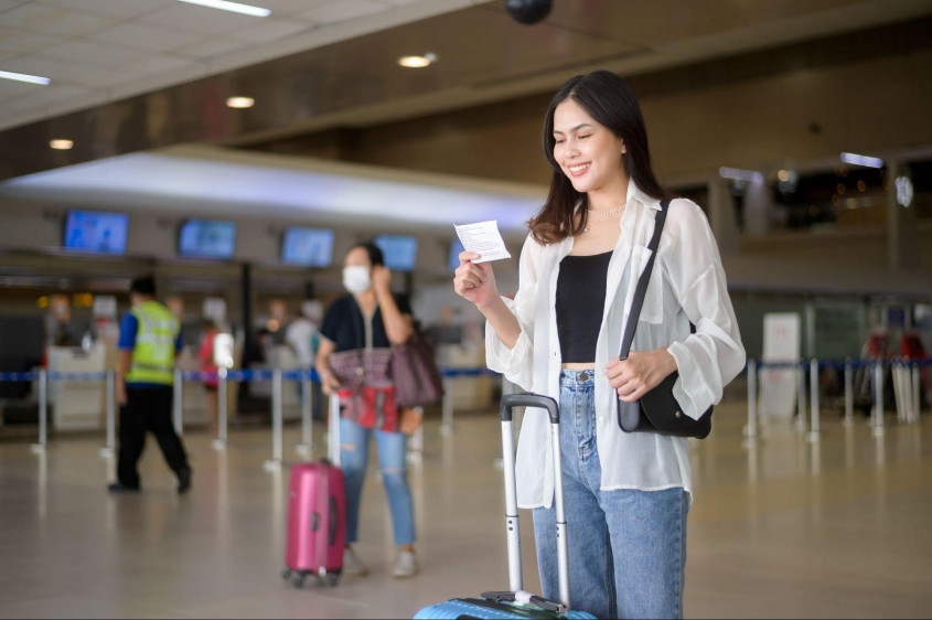 Genrebild över en kvinna som tittar på sin flygbiljett
