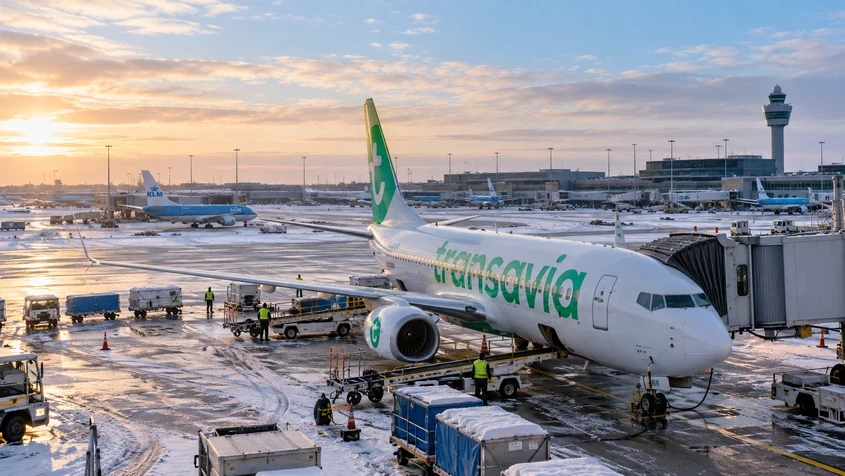 Transavia-vliegtuig aan de gate op een besneeuwd Schiphol