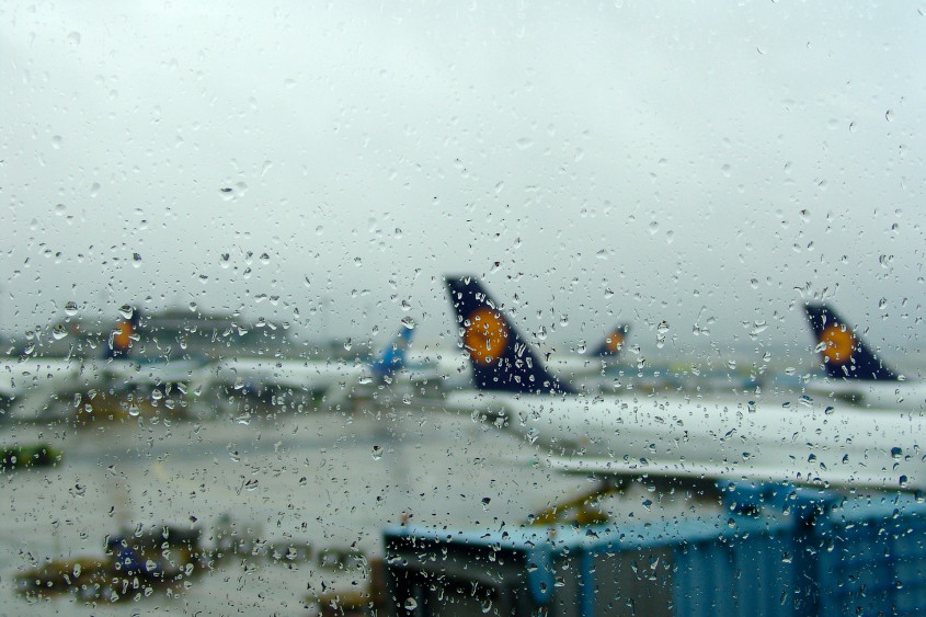 Lotnisko w deszczu, na którym widać opóźnienie lotu z powodu pogody