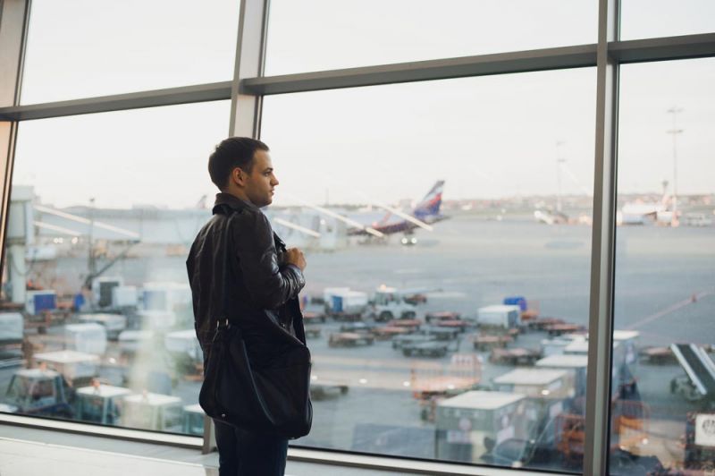 Man waiting for information about flight delays in Manchester Airport