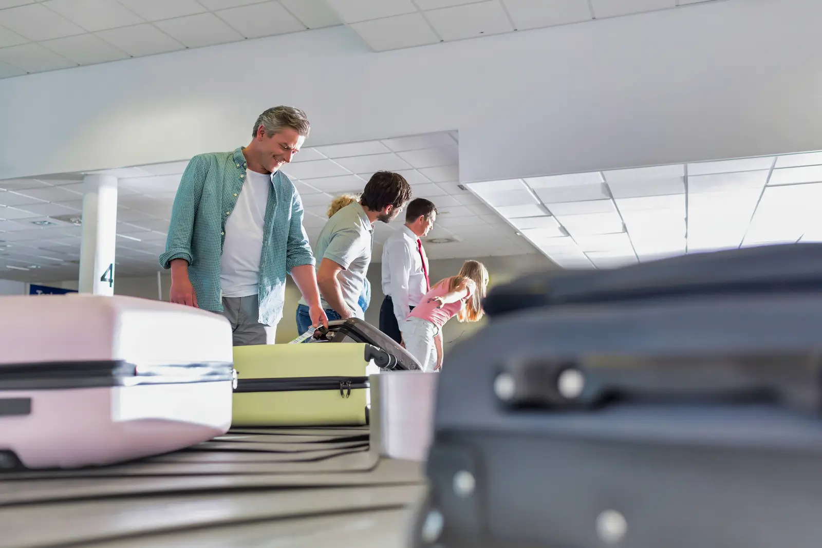 man getting his suitcase on baggage claiming area in airport