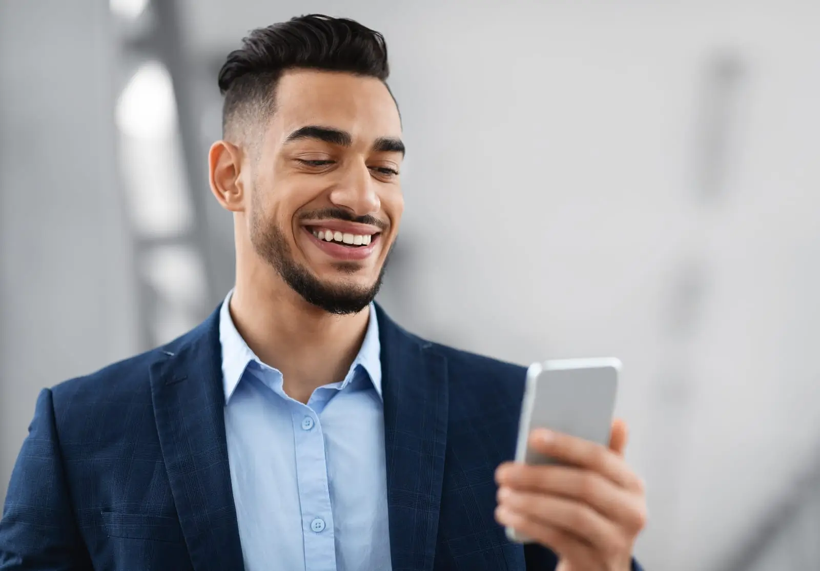 homme en costume tenant un smartphone