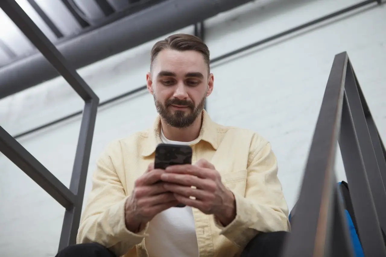 hombre usando teléfono inteligente en casa