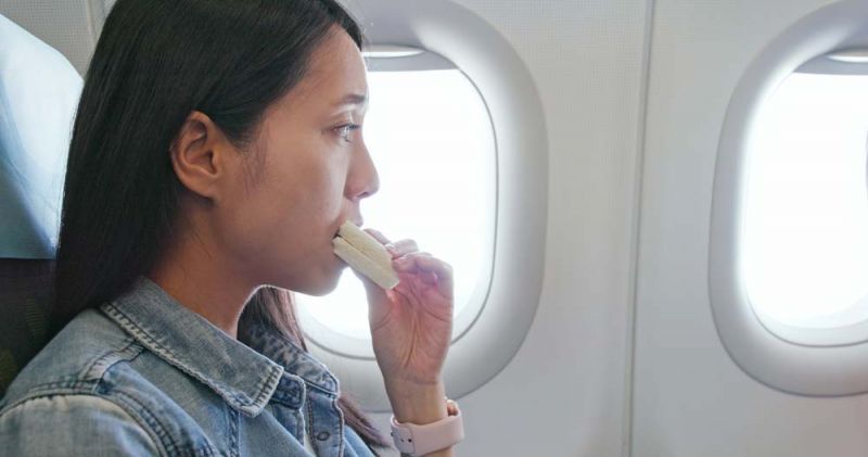 Pasajera en avión come un bocadillo que llevaba como comida en su maleta de mano