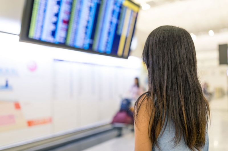Pasajera frente a panel informativo viendo la afectación de vuelos por huelga de Germanwings