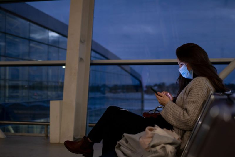 Pasajera sentada en el aeropuerto esperando por los retrasos de vuelos en Barcelona