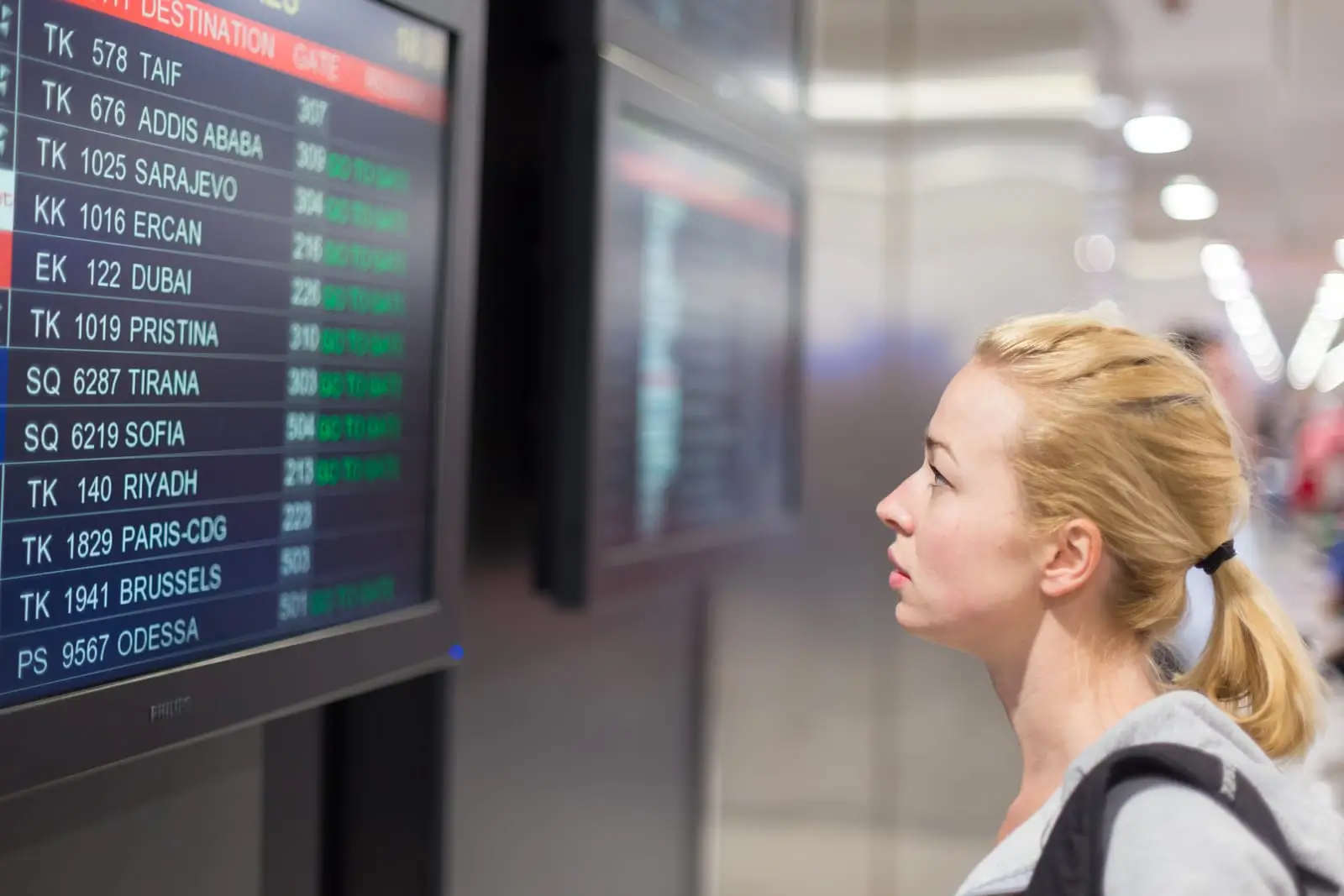 Passagier schaut auf Fluginformationsanzeige