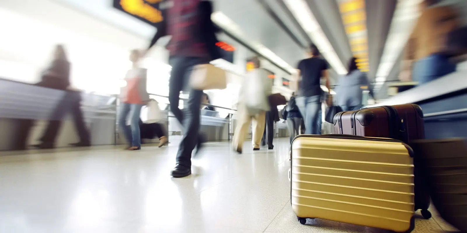 m&auml;nniskor som r&ouml;r sig i flygplatshallen genom resv&auml;skor