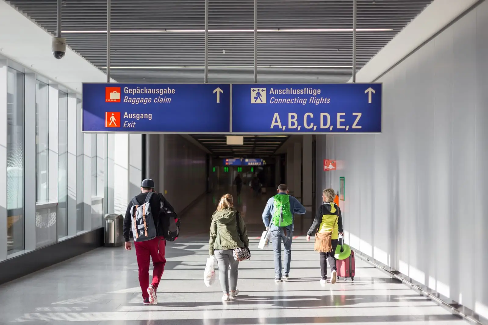 people with bags walking in airport terminal