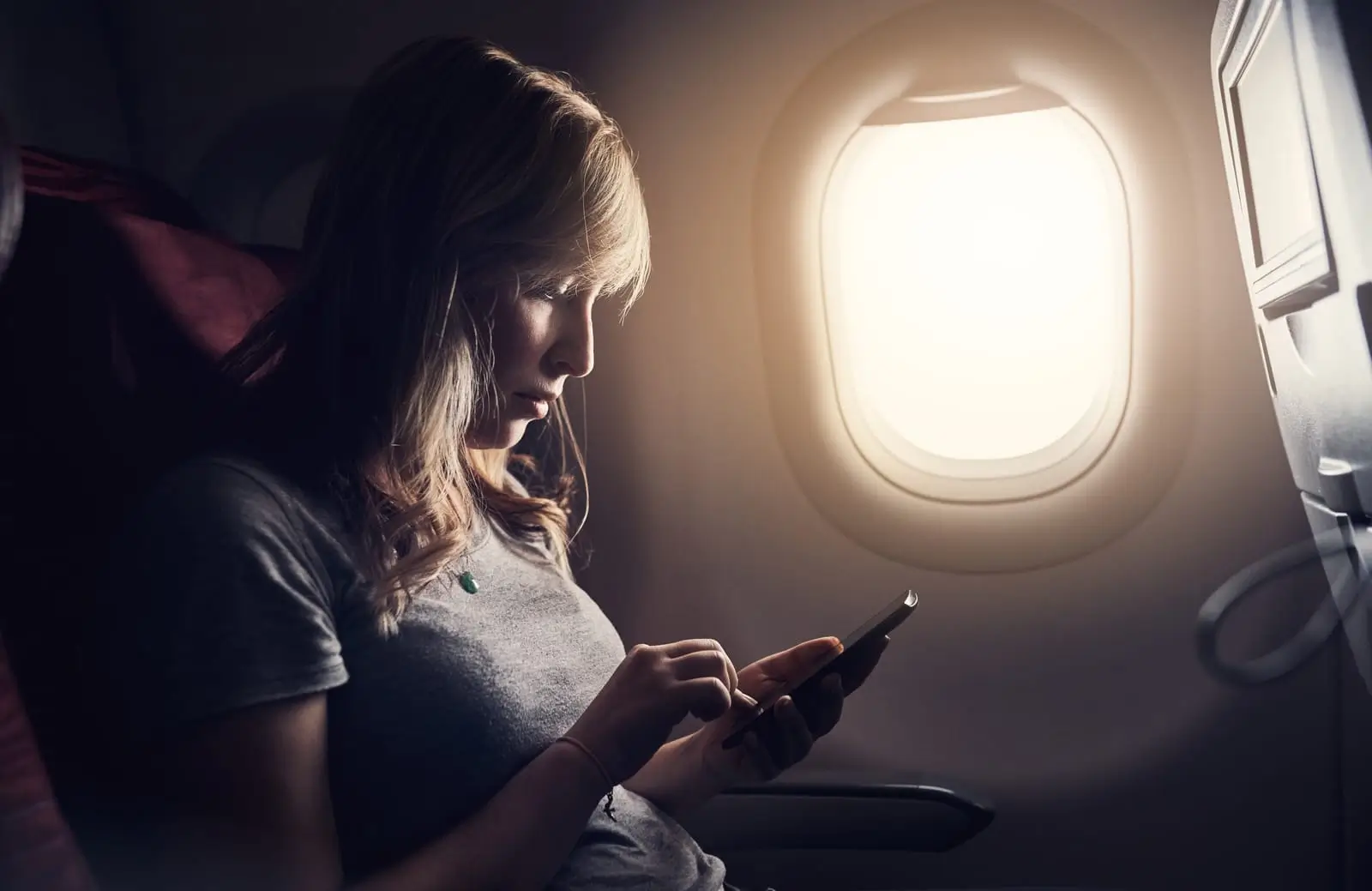 personne dans un avion avec un smartphone