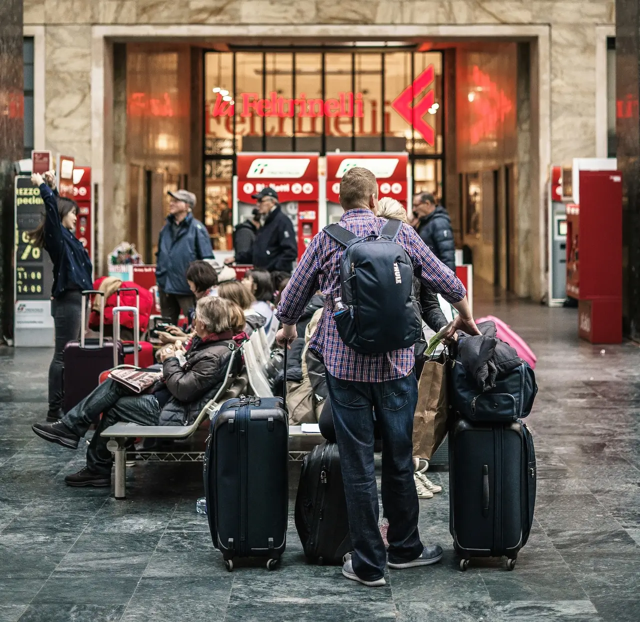 Podr&oacute;żni czekający z bagażem na lotnisku podczas op&oacute;źnienia lotu
