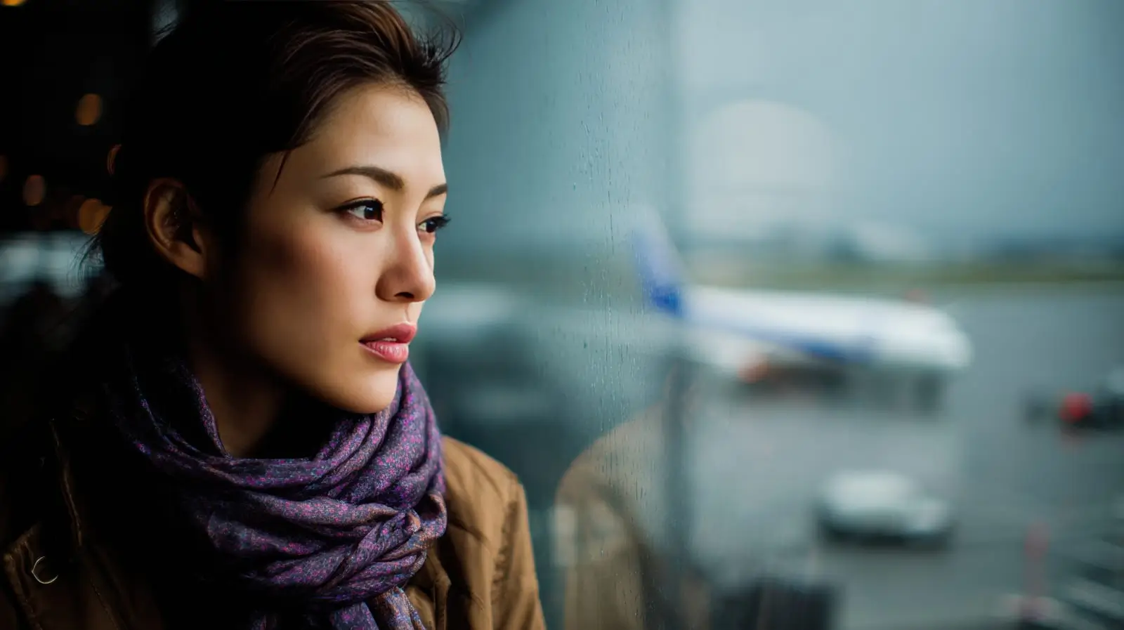 a woman standing at the window it the airport