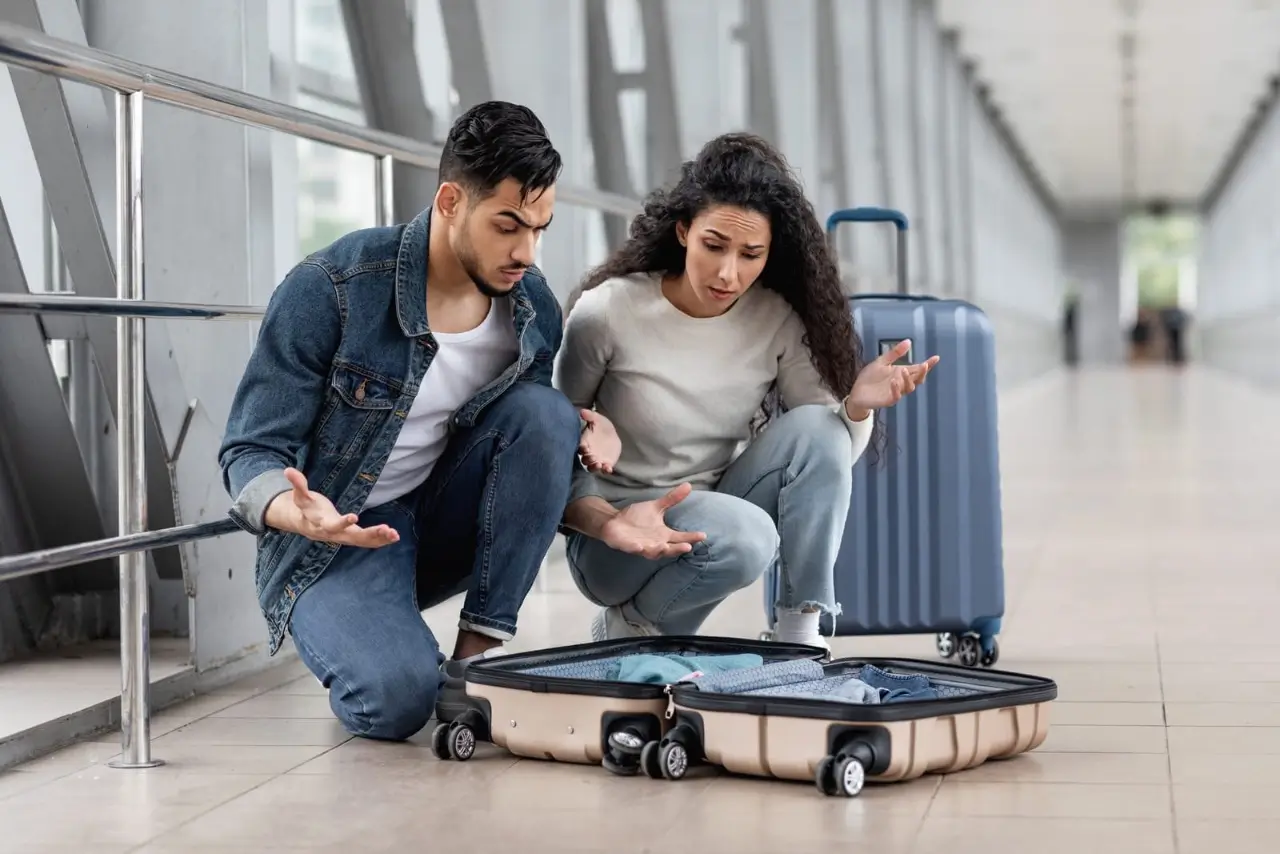 un couple de voyageurs a un probl&egrave;me avec leur valise