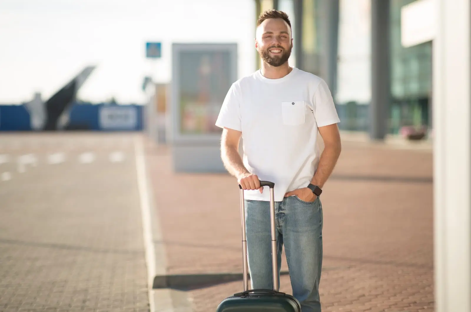 toerist die met bagage bij de luchthaventerminal staat