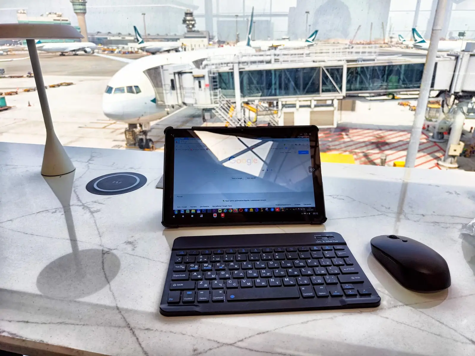 Reisender arbeitet mit einem Tablet am Flughafen